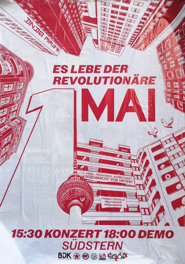 Ein Poster mit rotem Text und Illustrationen auf weißem Hintergrund. Oben steht "Es lebe der revolutionäre 1. Mai" in großen Buchstaben. Darunter sind Gebäude, die in die Mitte des Posters zeigen. Vorne ist der Berliner Fernsehturm abgebildet. Auf zwei Transparenten steht "Krieg, Faschismus, Ausbeutung? Gegenmacht von unten!" und "Freiheit für alle politischen Gefangenen!" Unten steht "15:30 Konzert 18:00 Demo Südstern". Verschiedene Logos sind am unteren Rand.