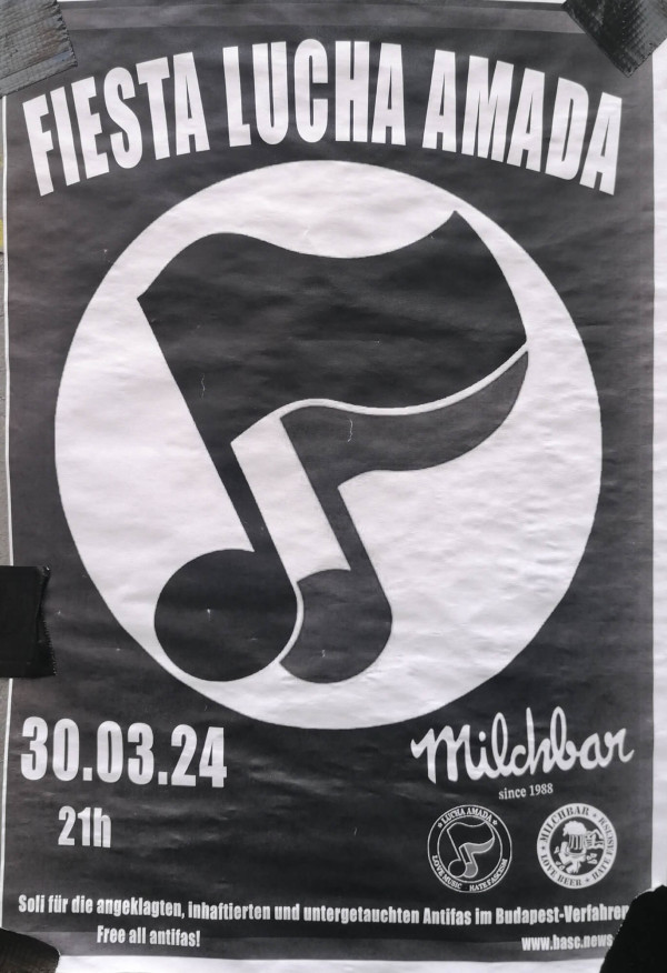 Ein schwarz-weißes Poster mit dem Text "Fiesta Lucha Amada" oben. Im Zentrum befindet sich ein großes Logo der Antifaschistischen Aktion abgeändert mit Musiknoten als Fahnenstangen vor einem schwarzen Hintergrund. Unten links steht "30.03.24, 21h". Rechts unten ist der Schriftzug "Milchbar since 1988", daneben zwei runde Logos. Am unteren Rand steht: "Soli für die angeklagten, inhaftierten und untergetauchten Antifas im Budapest-Verfahren. Free all antifas!"