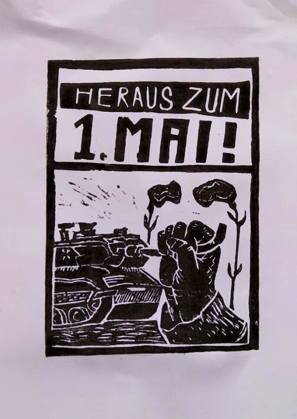 Ein schwarz-weißes Poster mit dem Text "Heraus zum 1. Mai!" im oberen Bereich. Darunter ist eine Hand abgebildet, die das Rohr eines Panzers verbiegt. Der Stil wirkt wie ein Holzschnitt mit kräftigen, kontrastreichen Linien.