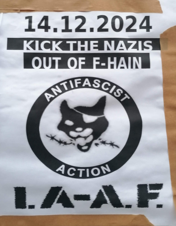Ein Poster auf weißem Hintergrund mit schwarzem Text und Grafiken. Oben steht das Datum "14.12.2024". Darunter in einem schwarzen Balken: "Kick the Nazis out of F-Hain". Zentral ist ein schwarzer Kreis mit einem illustriertem Gesicht einer Katze, die Stacheldraht aufbeißt. Im Kreis steht "Antifascist Action". Unten in großen Buchstaben "I.A-A.F.".