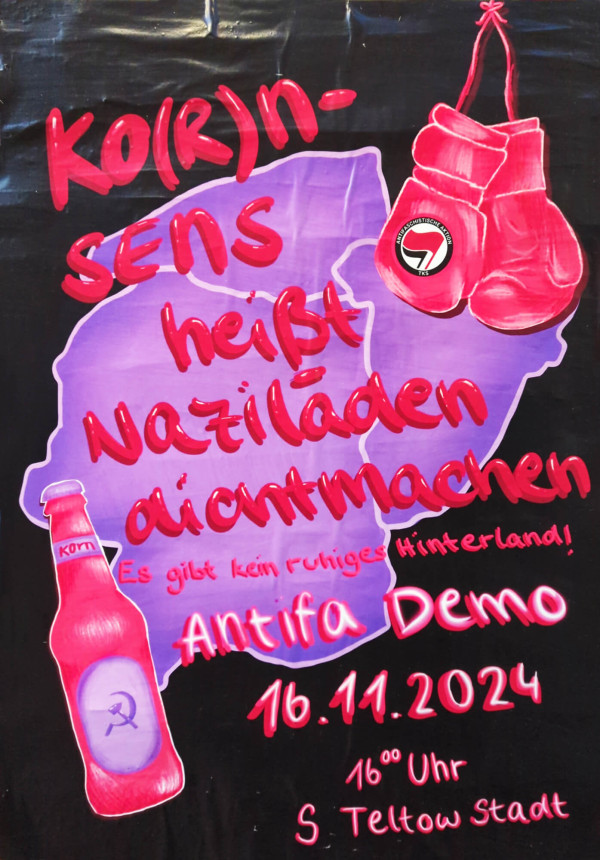 Ein Poster mit einem schwarzen Hintergrund zeigt eine lila Karte im Hintergrund. Darauf steht in roter Schrift: "Ko(r)n-sens heißt Naziläden dichtmachen". Rechts hängen rote Boxhandschuhe mit einem Antifa-Logo. Links ist eine rote Flasche mit Hammer und Sichel abgebildet, beschriftet mit "Korn". Unten steht: "Es gibt kein ruhiges Hinterland! Antifa Demo 16.11.2024", gefolgt von "16 Uhr S Teltow Stadt".