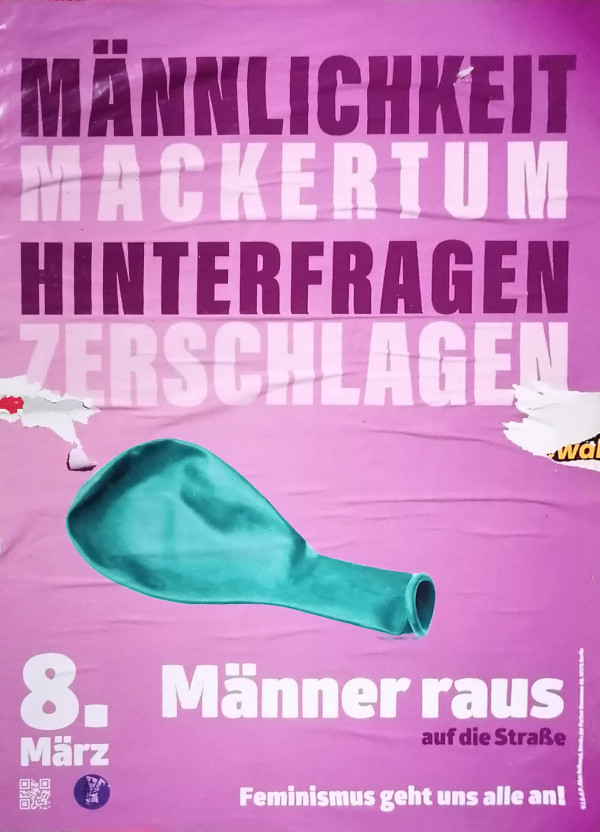 Ein Poster mit pinkem Hintergrund zeigt einen grünen, schlaffen Ballon. Oben steht in dunkler Schrift: "Männlichkeit hinterfragen. Mackertum zerschlagen". Unten links ist in Weiß "8. März" zu lesen. Rechts daneben steht: "Männer raus auf die Straße". Unten mittig steht: "Feminismus geht uns alle an!". Am unteren Rand befinden sich ein QR-Code und ein kleines Logo.