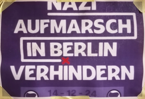 Ein Poster mit dunkelviolettem Hintergrund und weißem Text. Oben steht "Nazi Aufmarsch". Darunter in einem weißen, umrandeten Kasten steht "In Berlin" mit einem roten "x" darunter. Unten folgt "Verhindern". Die Schrift ist fett und in Großbuchstaben gehalten.