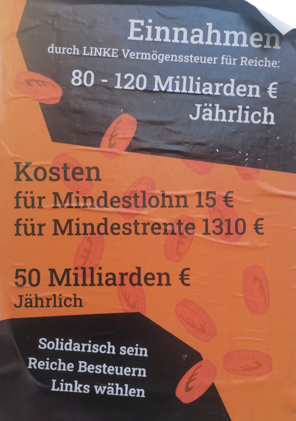 Ein Poster mit einem schwarz-orangen Hintergrund. Oben steht in Weiß auf Schwarz: "Einnahmen durch LINKE Vermögenssteuer für Reiche: 80 - 120 Milliarden € Jährlich". Darunter auf Orange steht in Schwarz: "Kosten für Mindestlohn 15 € für Mindestrente 1310 € 50 Milliarden € Jährlich". Unten links in Weiß auf Schwarz steht: "Solidarisch sein Reiche Besteuern Links wählen". Im Hintergrund sind Münzen mit einem Euro-Symbol abgebildet.